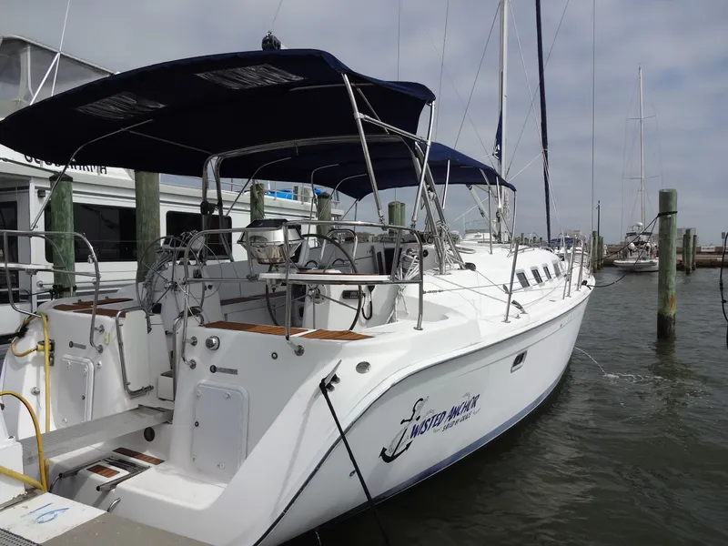 The Image of A 2009 Hunter 50 sailboat docked. It features a blue sunshade and a spacious cockpit. - 0