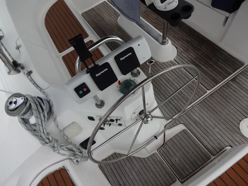 Slide: The Image of The image shows the cockpit of a 2009 Hunter 50 with a steering wheel and wooden flooring. - 27