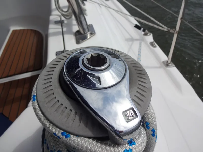 Slide: The Image of Close-up of a silver winch on a sailboat, surrounded by ropes and a wooden deck. - 10