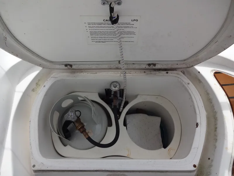 Slide: The Image of An open storage compartment with a propane tank and hose. - 9