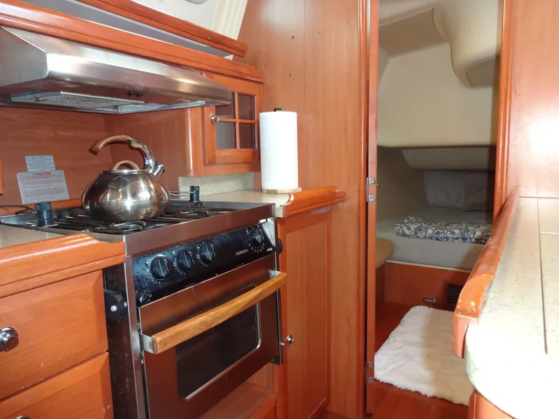 Slide: The Image of The interior of a 2009 Hunter 50 features a well-equipped galley with a stove and kettle. - 38