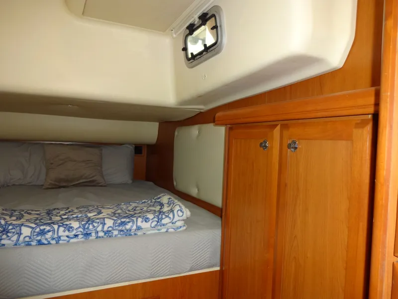 Slide: The Image of The cabin of a 2009 Hunter 50 features a cozy bed and wooden cabinets. - 41
