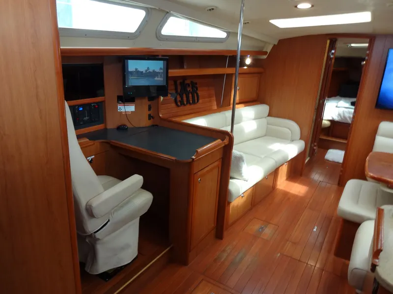 Slide: The Image of Interior of a 2009 Hunter 50 sailboat with wooden floors and white upholstered seating. - 34