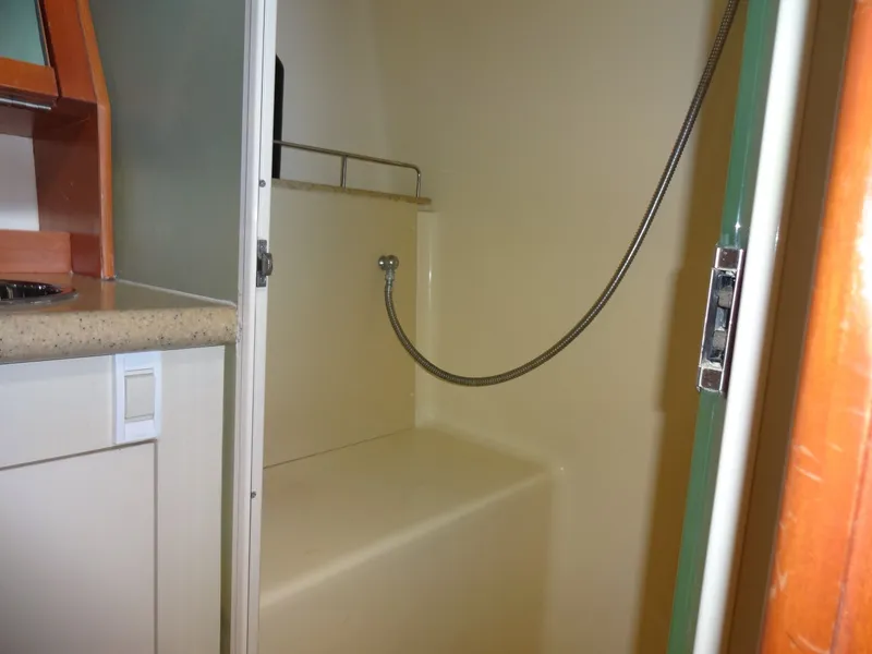 Slide: The Image of The yacht cabin shower features a handheld showerhead and a bench. - 48