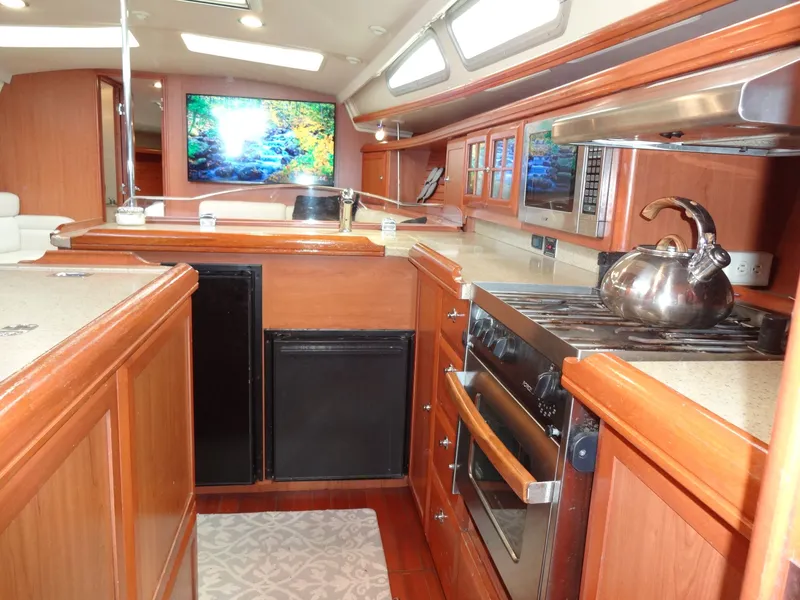 Slide: The Image of The galley of a 2009 Hunter 50 with wooden cabinets and modern appliances. - 45
