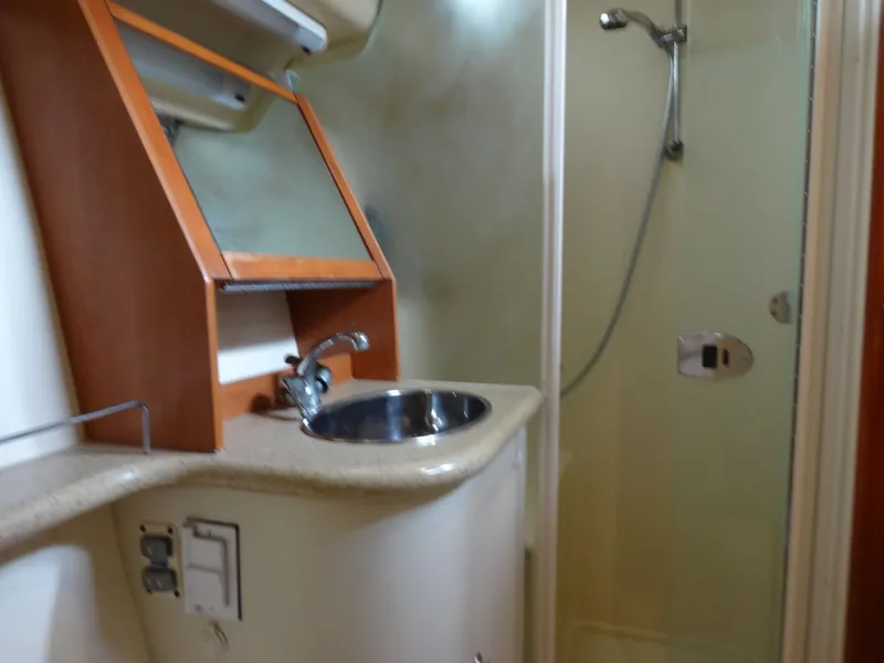 Slide: The Image of The image shows a boat bathroom with a sink and shower. - 47