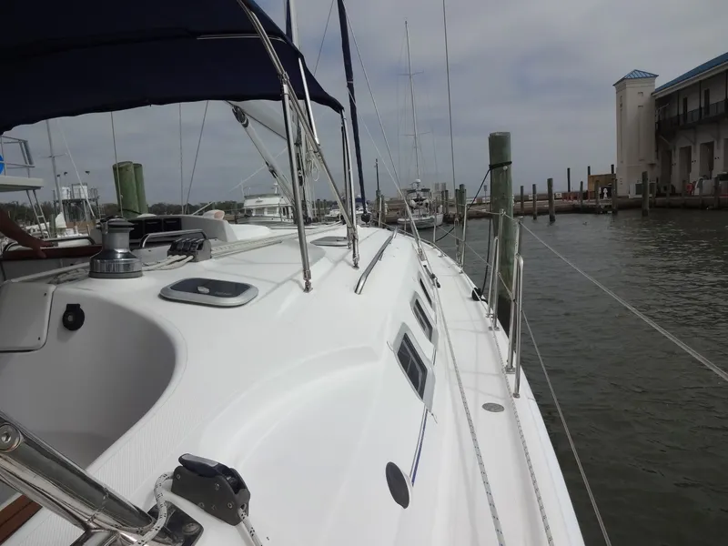 Slide: The Image of A 2009 Hunter 50 sailboat docked. It features a blue bimini top. - 18