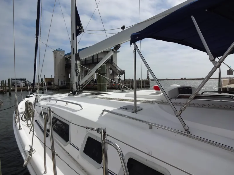Slide: The Image of A white sailboat docked, featuring a blue sunshade. It appears well-maintained and ready for sailing. - 4