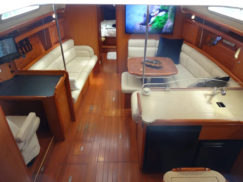 Slide: The Image of Interior of a 2009 Hunter 50 with wooden floors, beige sofas, and a dining table. - 31