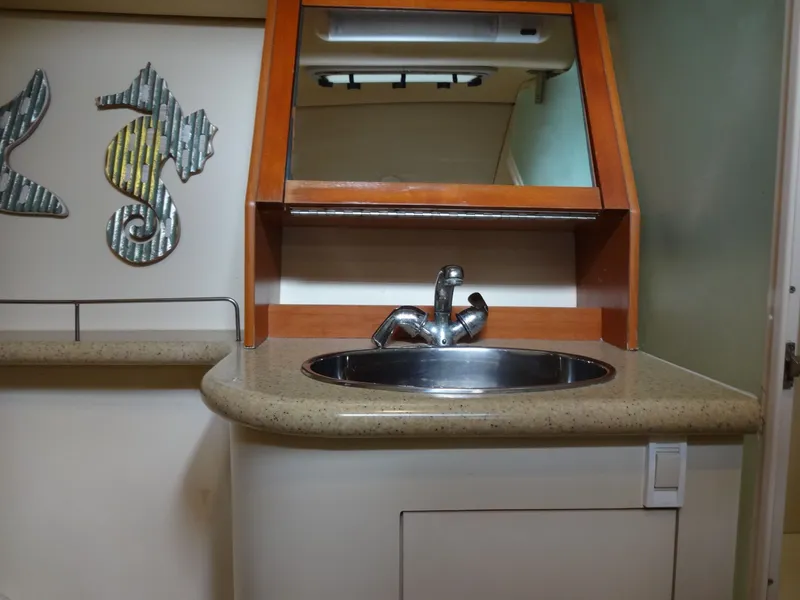 Slide: The Image of A sleek sink with a modern faucet in a boat bathroom, surrounded by wood paneling. - 49