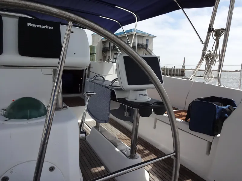 Slide: The Image of The cockpit of a 2009 Hunter 50 with a steering wheel, navigation system, and seating area. - 13