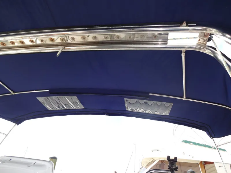 Slide: The Image of The image shows the blue canopy of a 2009 Hunter 50 boat with a metal frame. - 16