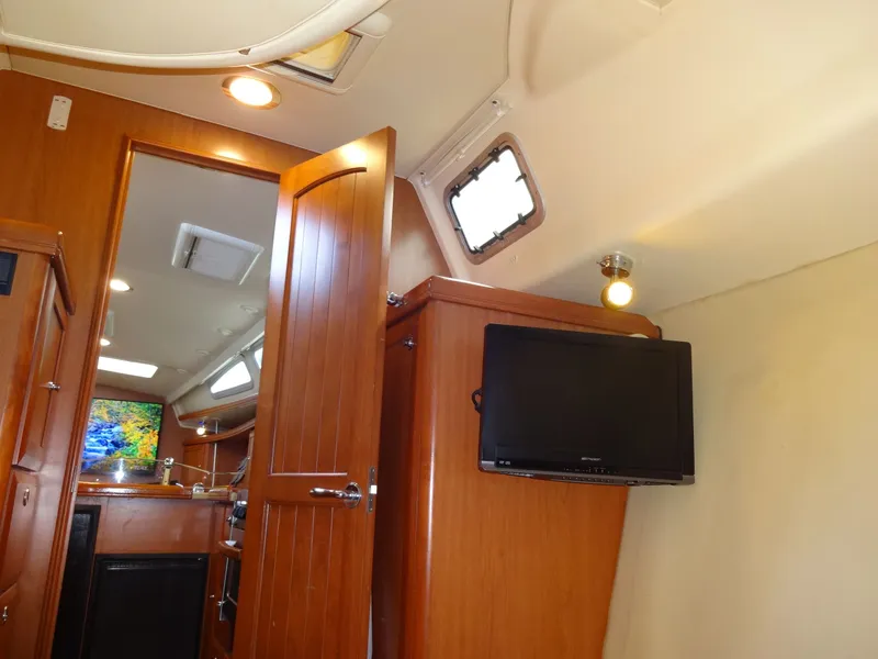 Slide: The Image of Interior of a 2009 Hunter 50 sailboat with wooden furnishings and a flat-screen TV. - 44
