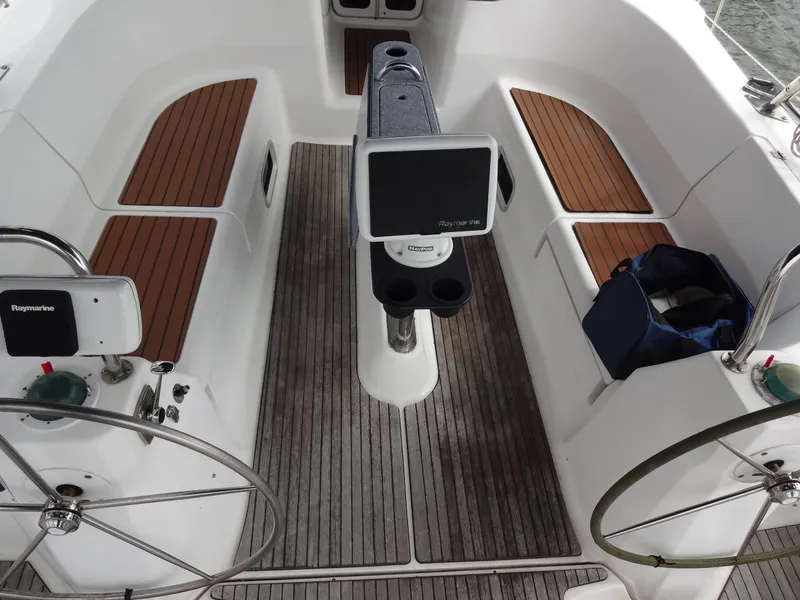 Slide: The Image of The cockpit of a 2009 Hunter 50 with wooden benches and a central helm station. - 28