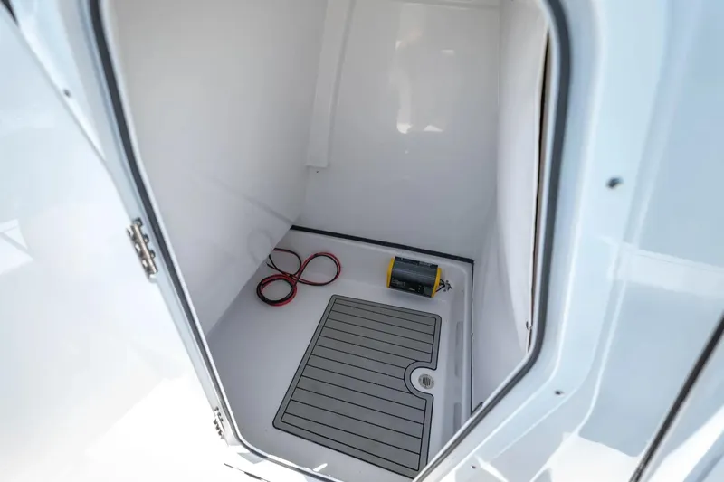 Slide: The Image of 2026 Sportsman Masters 247 Bay Boat interior storage compartment with mat and cables. - 9