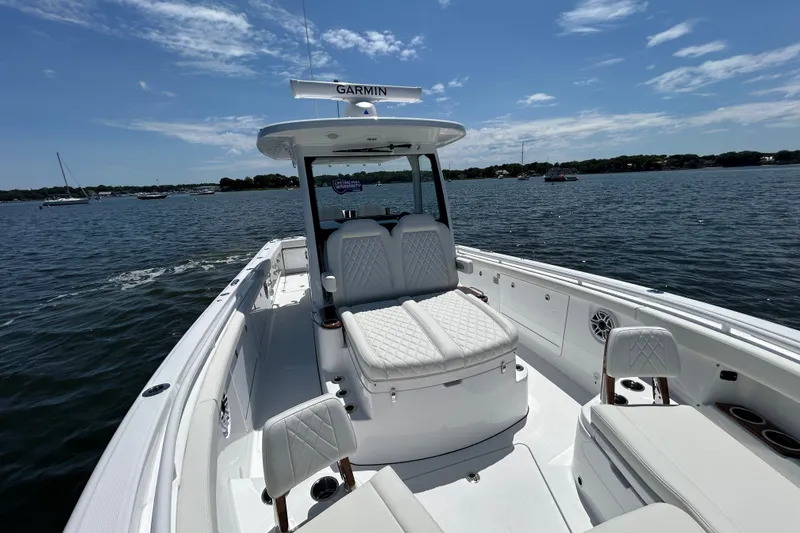 Slide: The Image of 2027 Everglades 315 Center Console boat on calm water, featuring luxurious seating and Garmin equipment. - 29