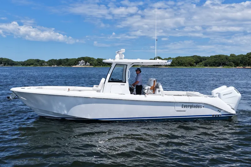 Slide: The Image of 2027 Everglades 315 Center Console boat on water, clear sky background. - 10