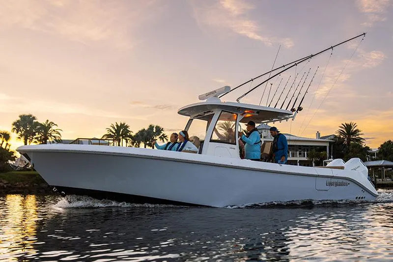 Slide: The Image of Manufacturer Provided Image: 2025 Everglades 315 Center Console boat cruising on a scenic waterway at sunset. - 1