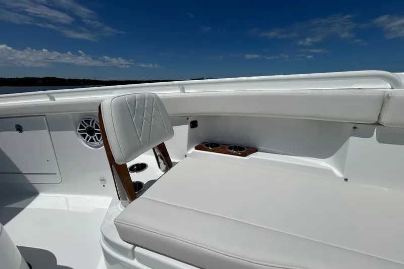 Slide: The Image of 2027 Everglades 315 Center Console boat interior with white seating and cup holders. - 37