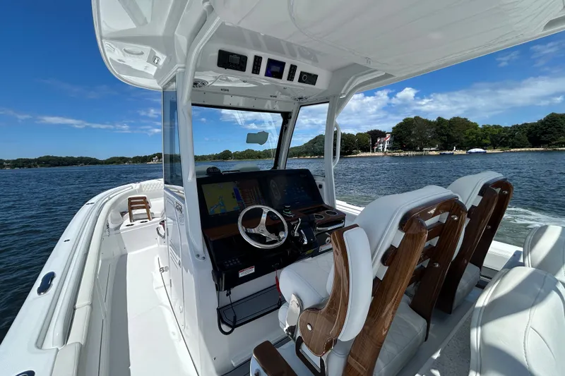 Slide: The Image of 2027 Everglades 315 Center Console boat on water, featuring modern helm and seating. - 23