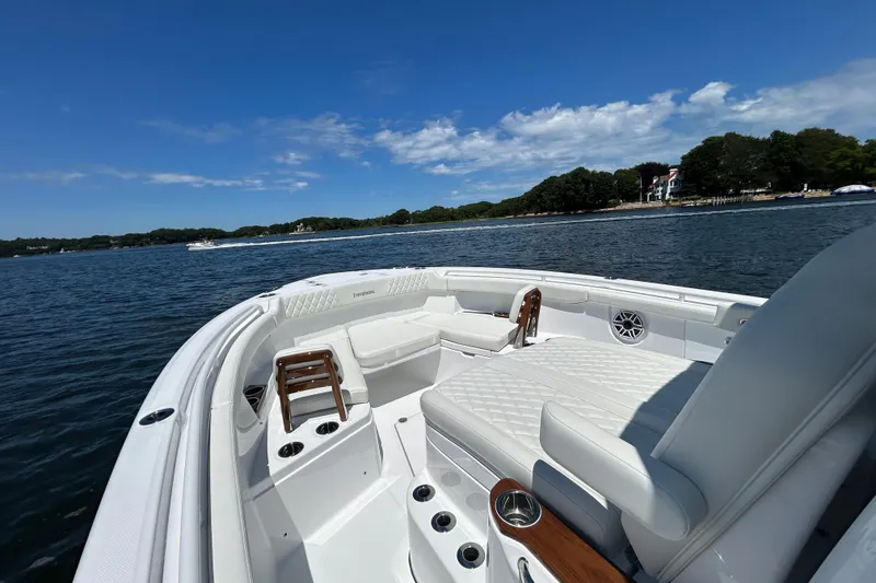 Slide: The Image of 2027 Everglades 315 Center Console boat on calm water, featuring luxurious seating and clear skies. - 28