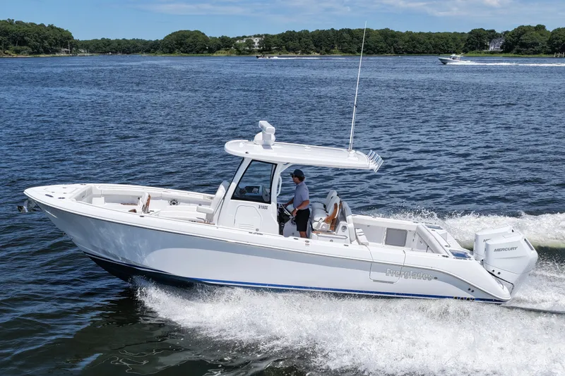 The Image of 2027 Everglades 315 Center Console boat cruising on a scenic waterway. - 0
