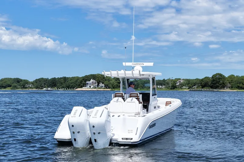 Slide: The Image of 2027 Everglades 315 Center Console boat cruising on a scenic lake. - 6