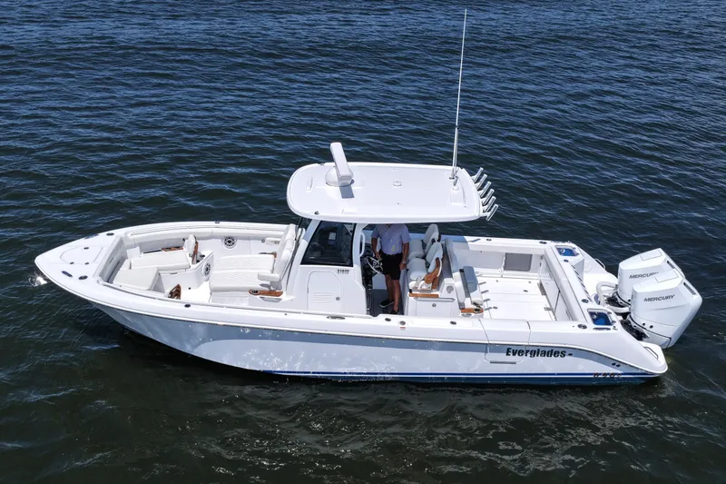 Slide: The Image of 2027 Everglades 315 Center Console boat on water, featuring sleek design and dual engines. - 15