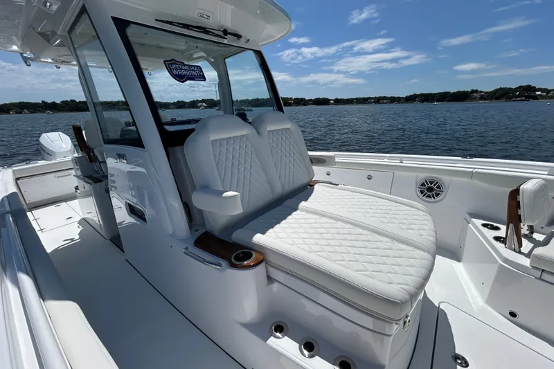Slide: The Image of 2027 Everglades 315 Center Console boat interior with luxurious seating on a sunny day. - 30