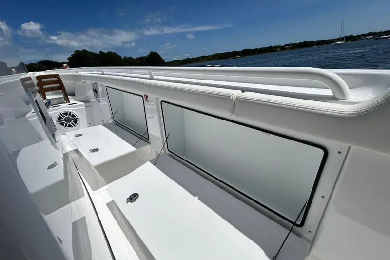 Slide: The Image of 2027 Everglades 315 Center Console boat interior with seating and storage, on a sunny day. - 34