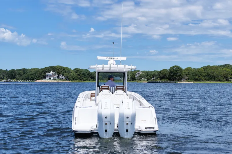 Slide: The Image of 2027 Everglades 315 Center Console boat cruising on a scenic lake under a blue sky. - 7