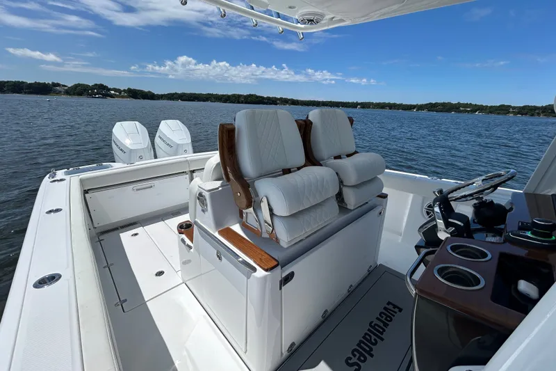 Slide: The Image of 2027 Everglades 315 Center Console boat interior with dual engines on a serene lake. - 40