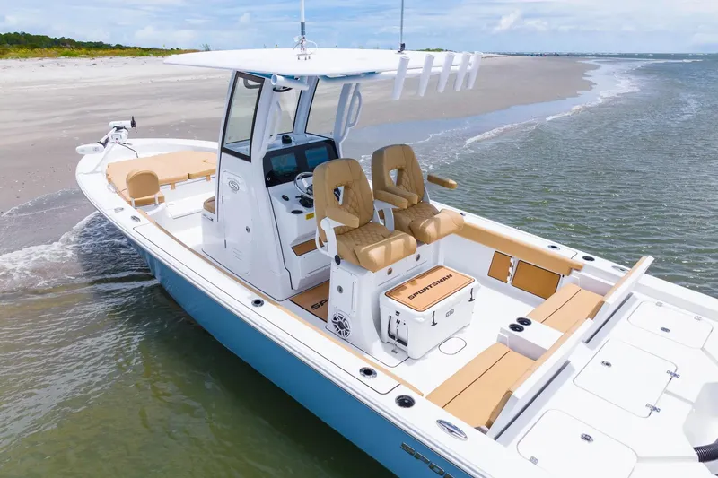 Slide: The Image of 2026 Sportsman Masters 267 Bay Boat on sandy shore, featuring tan seating and modern design. - 1