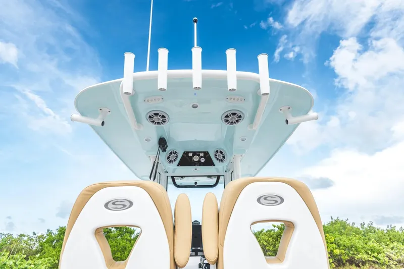 Slide: The Image of 2026 Sportsman Masters 267 Bay Boat, featuring rod holders and speakers under a clear blue sky. - 11