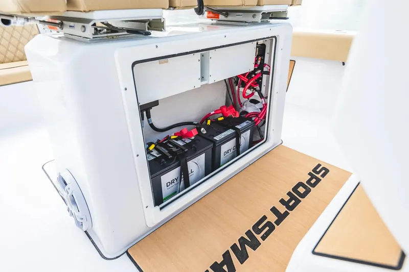 Slide: The Image of 2026 Sportsman Masters 267 Bay Boat battery compartment with wiring and storage. - 14