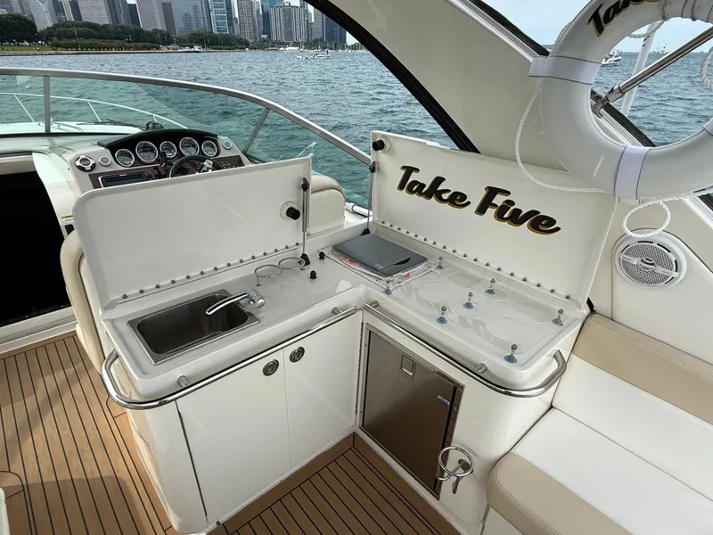Slide: The Image of The 2013 Sea Ray 370 Venture features a sleek outdoor kitchenette with a sink and storage. - 17