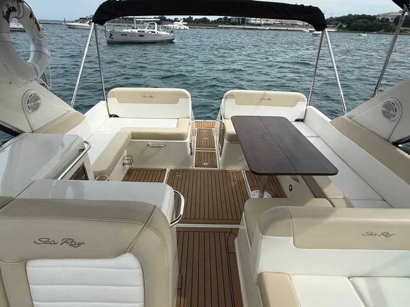 Slide: The Image of The image shows the cockpit of a 2013 Sea Ray 370 Venture with elegant seating and a wooden table. - 13