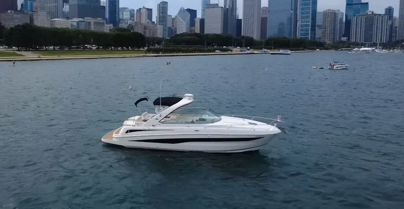 The Image of A 2013 Sea Ray 370 Venture cruising on calm waters with a city skyline in the background. - 0