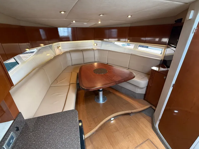 Slide: The Image of The 2013 Sea Ray 370 Venture interior features an elegant seating area with a wooden table. - 36