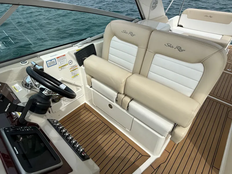 Slide: The Image of The image shows the cockpit of a 2013 Sea Ray 370 Venture with beige and white seating. - 16