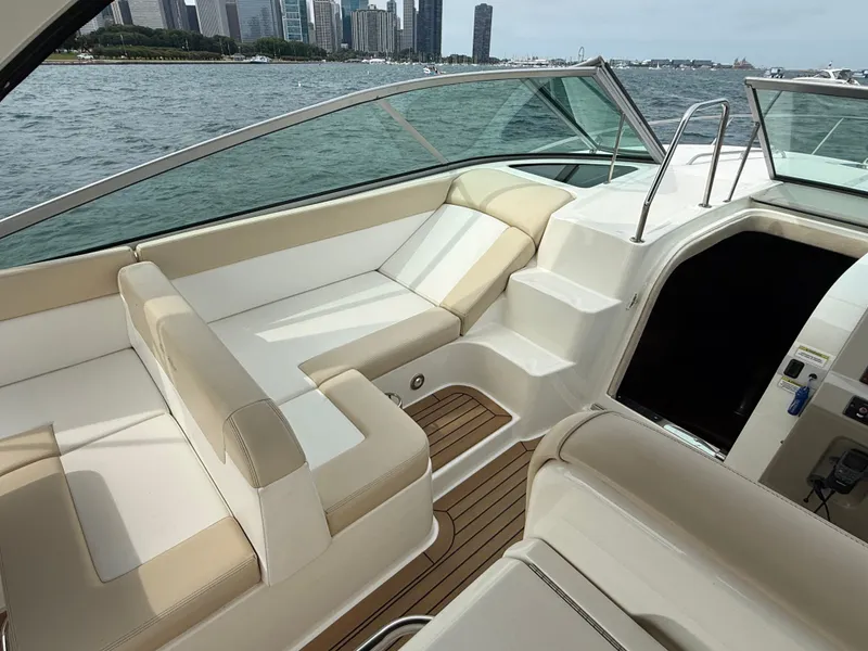 Slide: The Image of The image shows the cockpit of a 2013 Sea Ray 370 Venture with beige upholstery and a skyline view. - 11