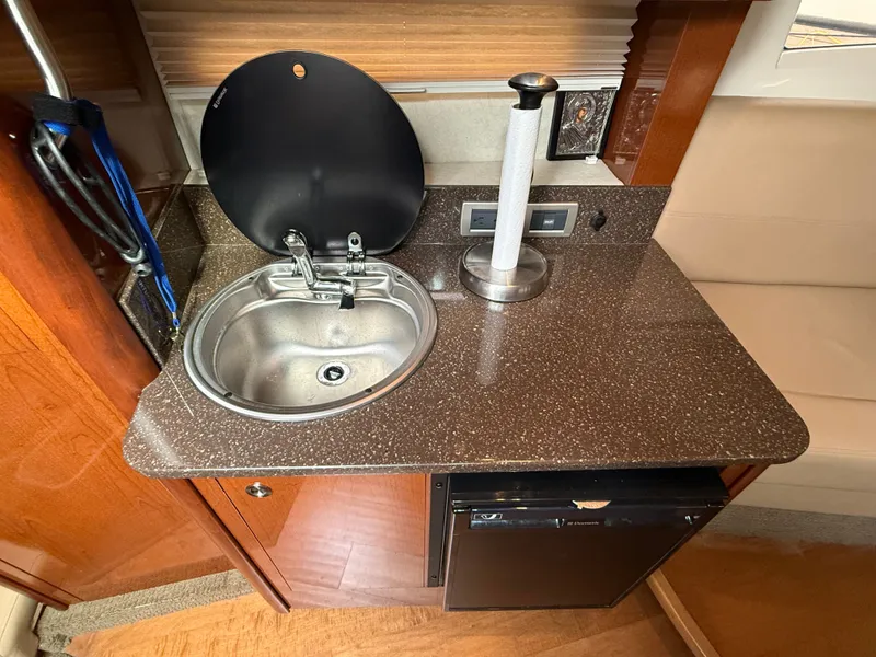 Slide: The Image of Compact kitchenette with sink, countertop, and mini-fridge in a Sea Ray 370 Venture. - 34