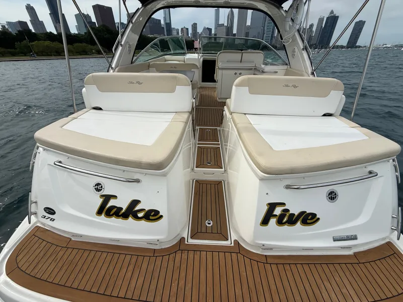 Slide: The Image of The image shows a 2013 Sea Ray 370 Venture named "Take Five." It's on the water with a city skyline in the background. - 4