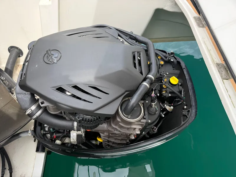 Slide: The Image of An engine compartment with a modern engine, partially covered, inside a boat. - 30