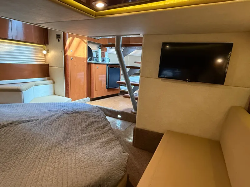 Slide: The Image of Interior of a 2013 Sea Ray 370 Venture with cozy bed, sofa, and TV. - 41