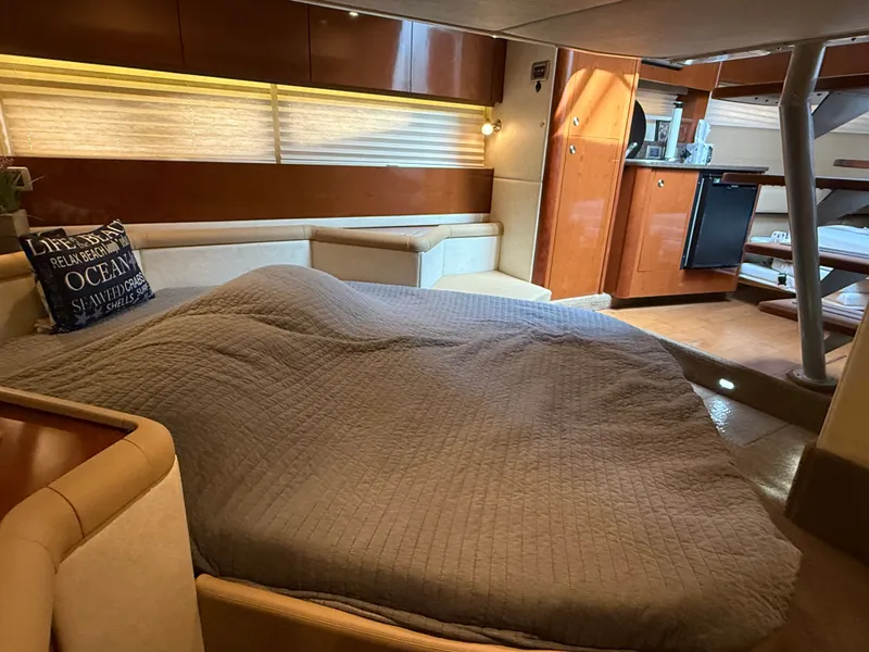 Slide: The Image of The cabin of a 2013 Sea Ray 370 Venture features a cozy bed and a kitchenette. - 42