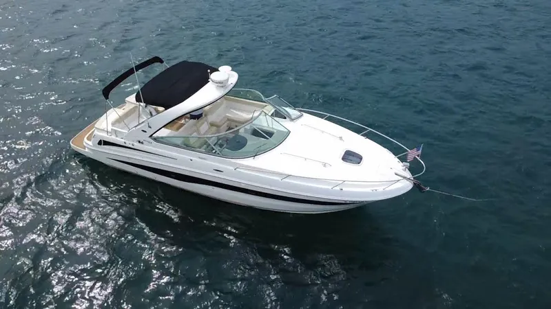 Slide: The Image of A 2013 Sea Ray 370 Venture on the water with a black canopy and American flag. - 1