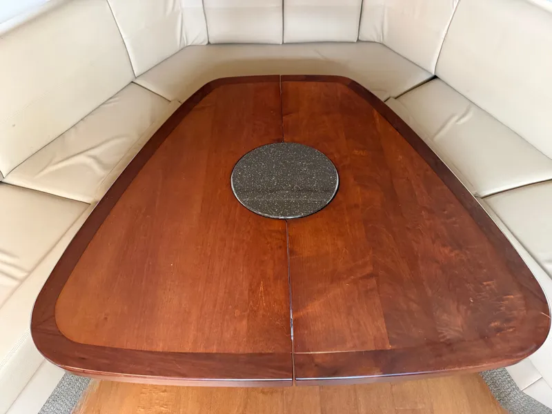 Slide: The Image of A sleek wooden table with a round insert, surrounded by beige upholstered benches. - 38