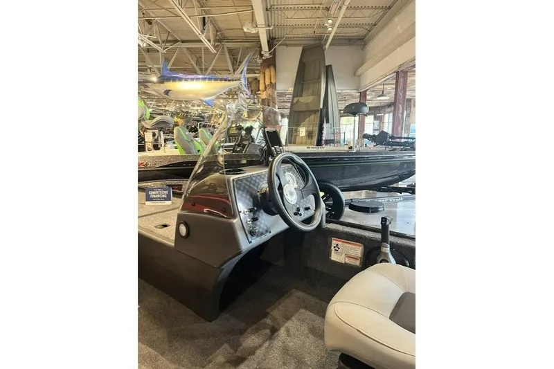 The Image of 2027 Tracker Bass Tracker Classic XL boat interior with steering wheel and seating in showroom. - 1
