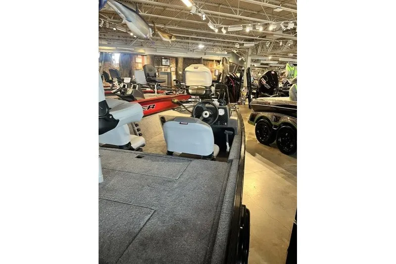 Slide: The Image of 2027 Tracker Bass Tracker Classic XL boat displayed in a showroom with other boats. - 10
